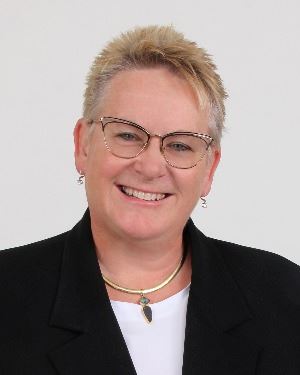 Smiling woman wearing glasses and black blazer