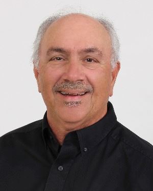 smiling man with a mustache in a black shirt