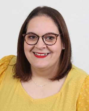 Smiling woman wearing glasses and yellow shirt